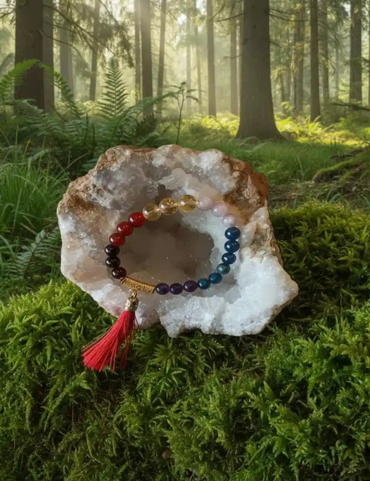 Bracelet 7 chakras dans géode cristal de roche reposant sur tapis de mousse avec fond de nature - Collection