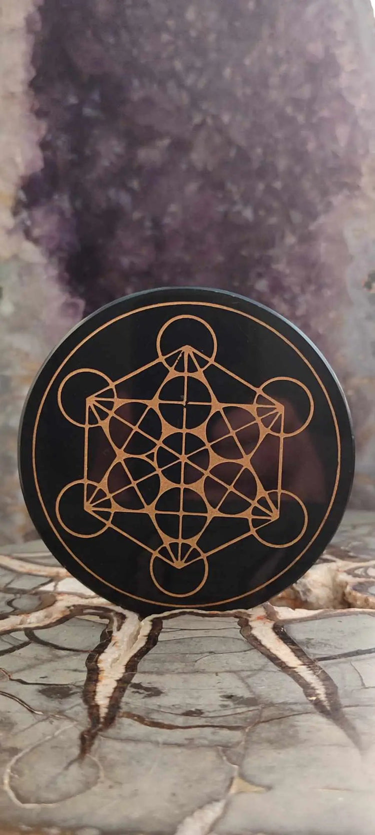 Sous-verre noir rond avec motif géométrique doré dans la collection Disque sceau de Métatron