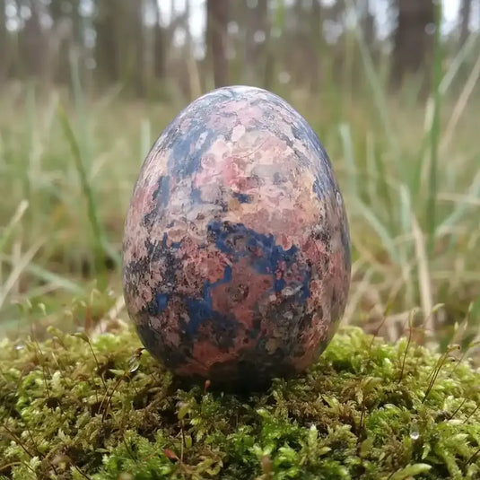 Œuf Tantra Yoni en Jaspe léopard, sur tapis de mousse fraiche et forêt en arrière plan