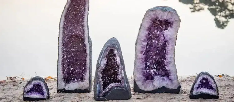 Géodes d'améthyste violette de tailles variées, mettant en valeur leurs intérieurs cristallins et leurs coquilles extérieures gris foncé.